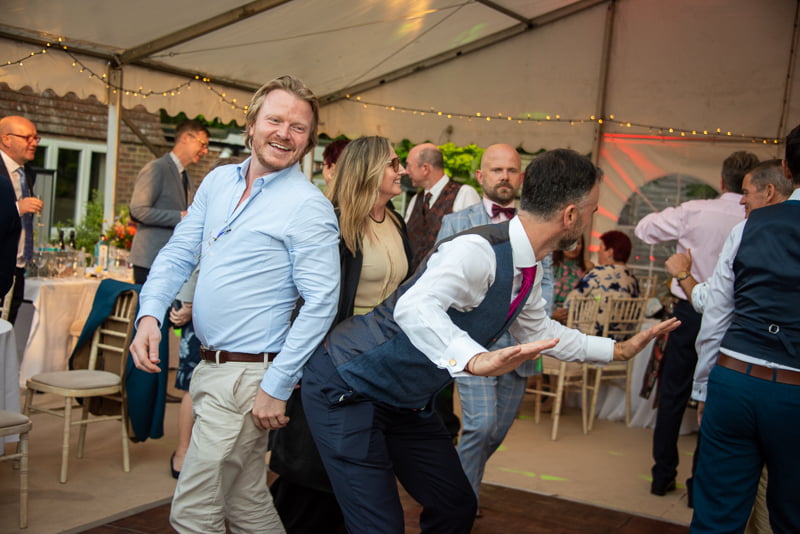 Two wedding guests dancing on dancefloor after wedding by Nick Ford Photography