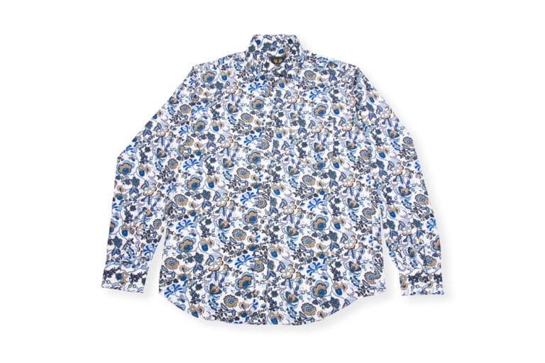Button-down shirt featuring a blue floral design, displayed on a simple white background, showcasing its vibrant pattern and modern, stylish appeal.