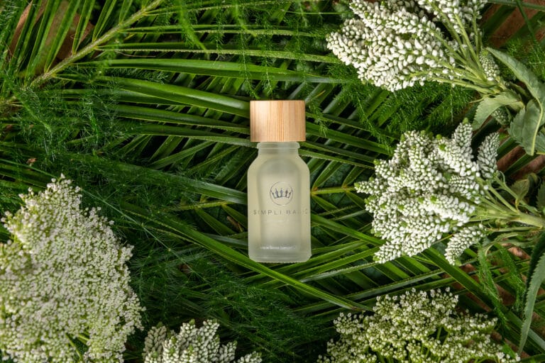 Essential oils placed amid a backdrop of lush green foliage, highlighting the natural, calming essence of the oils while blending seamlessly with the vibrant, organic surroundings.