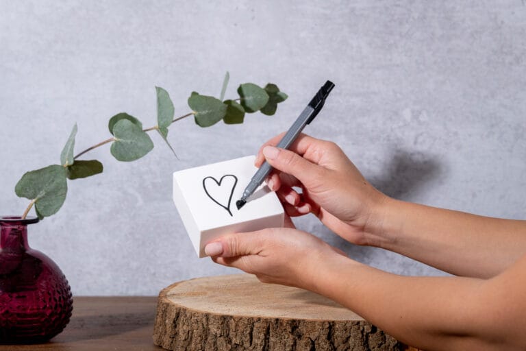 Hand model holding a diffusing white block with one hand and drawing a heart on it with the other, capturing a creative and serene moment that highlights the elegant design and calming atmosphere of the diffuser.