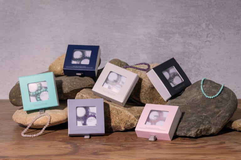 Creative group shot of several bracelets arranged on a cluster of stones, highlighting the intricate designs and textures of the jewelry against the natural, rugged backdrop.