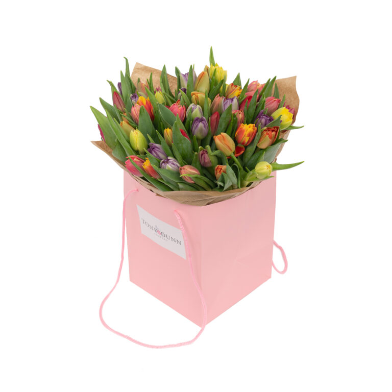 Card bag filled with flowers, set against a simple white background, highlighting the vibrant blooms and charming, rustic presentation.