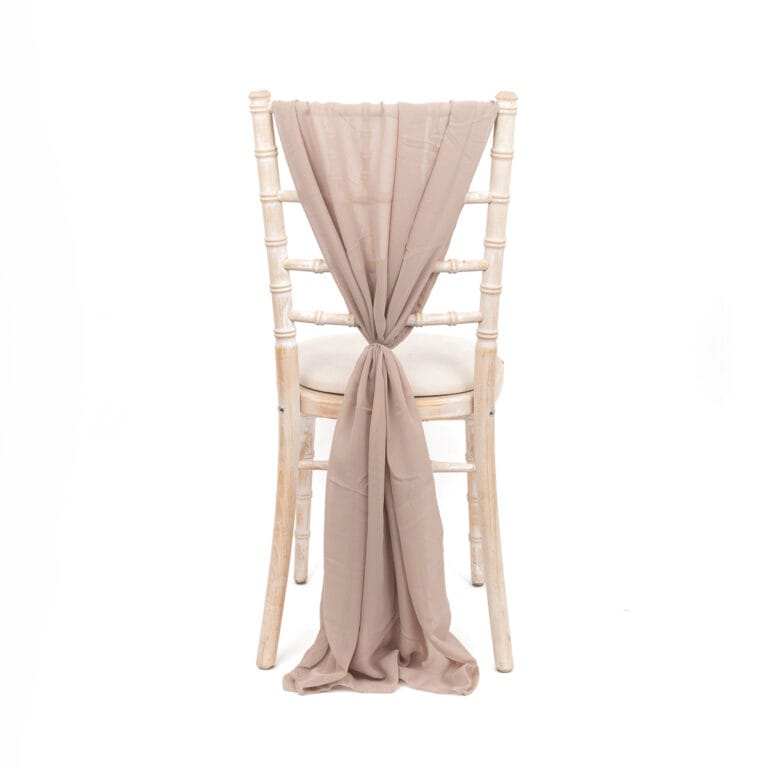 White-washed wooden chair with off white fabric, expertly photographed to highlight its elegant design and vibrant wedding decor potential.
