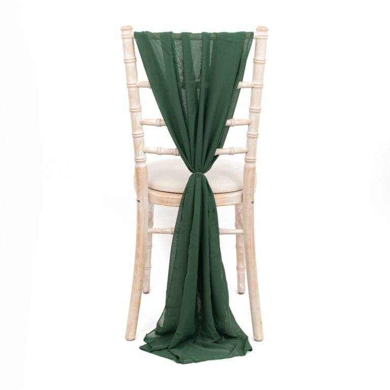 White-washed wooden chair with dark green fabric, expertly photographed to highlight its elegant design and vibrant wedding decor potential.
